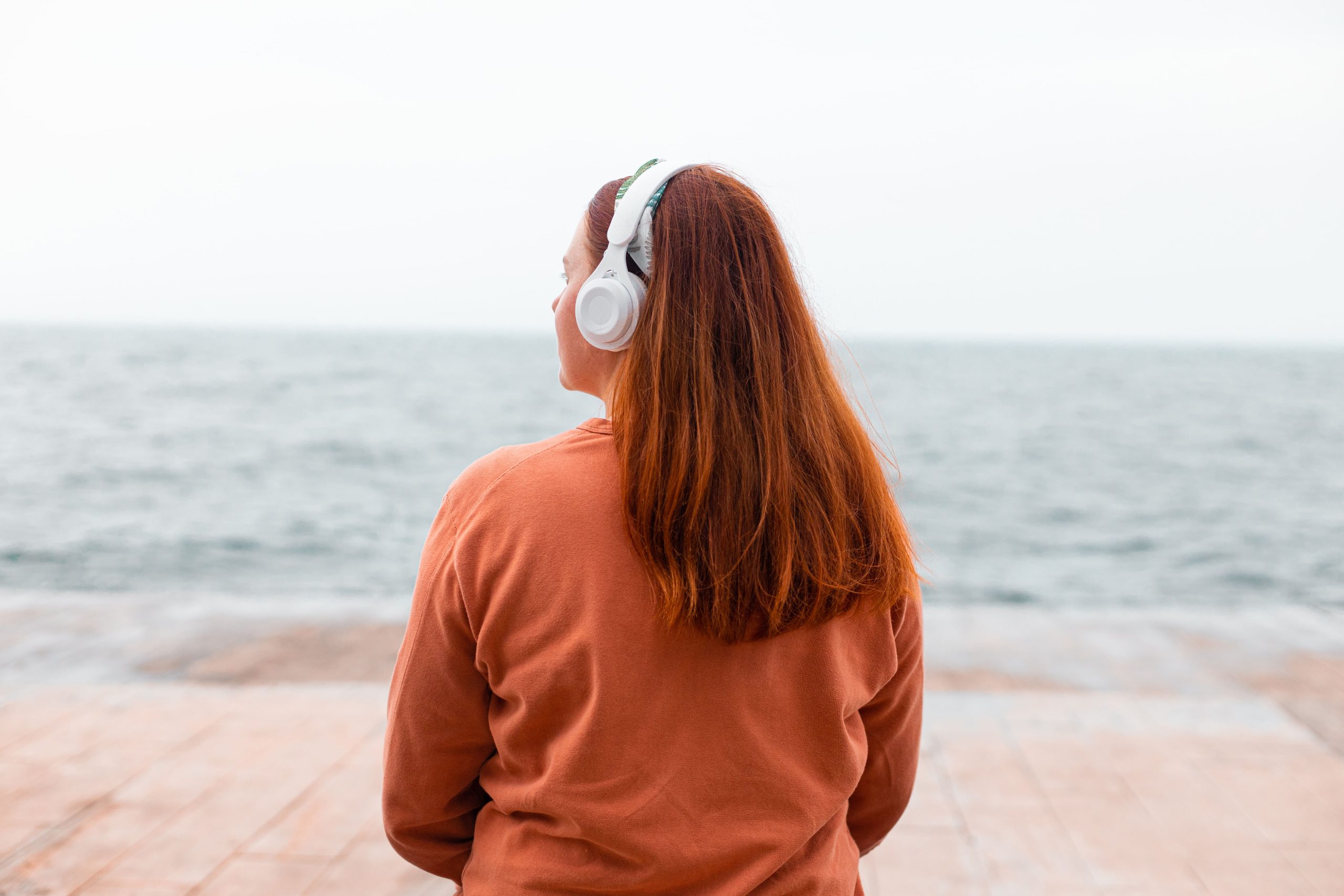 Mujer joven de espaldas con auriculares