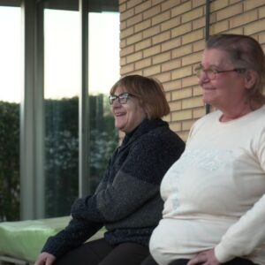 Dos mujeres de edad avanzada sentadas en un banco.
