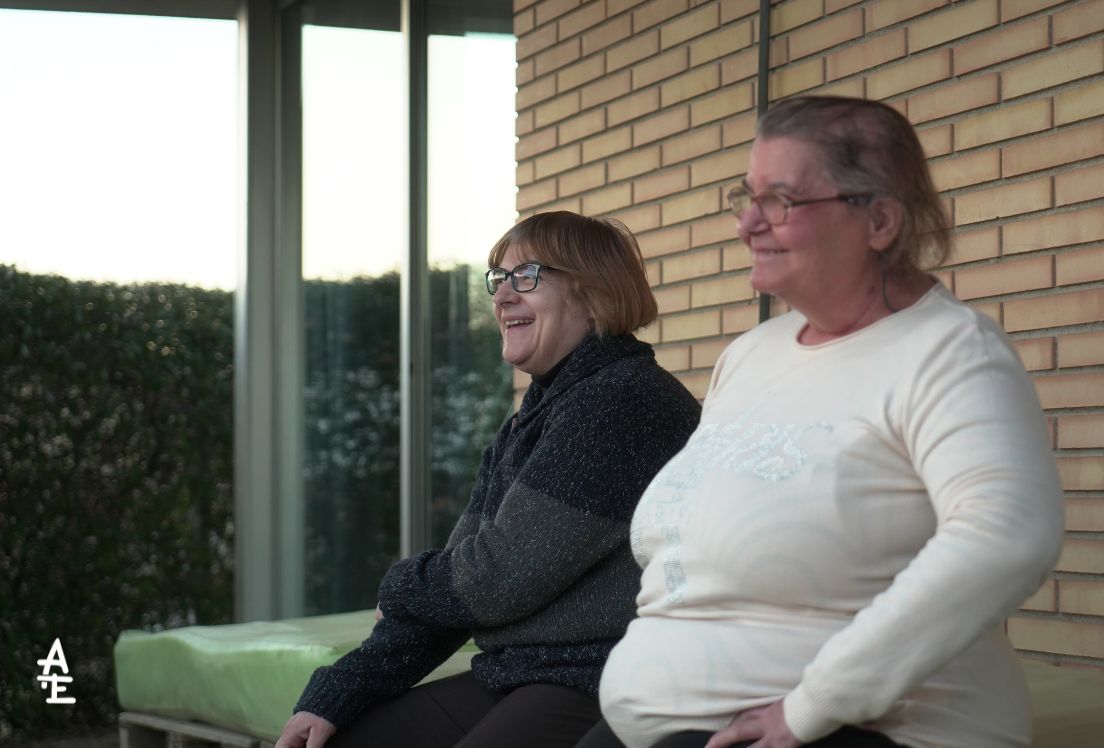 Dos mujeres de edad avanzada sentadas en un banco.