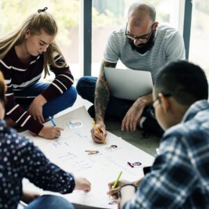 Grupo de personas trabajando en equipo sobre un documento.
