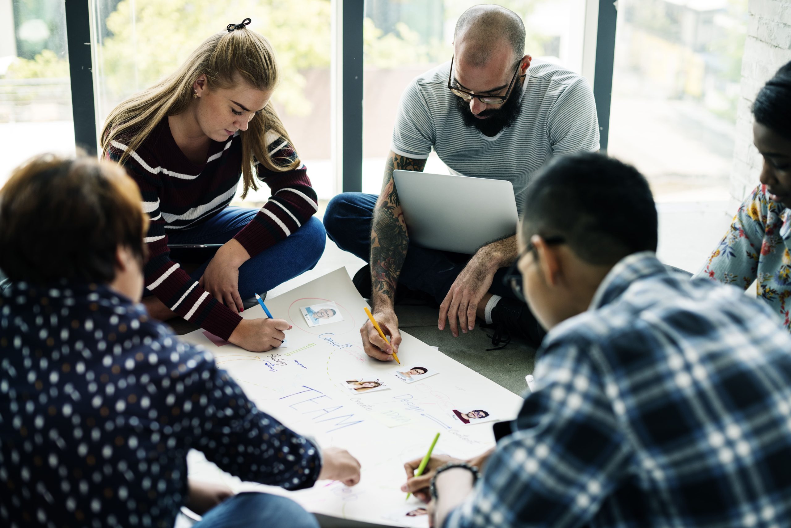 Grupo de personas trabajando en equipo sobre un documento.