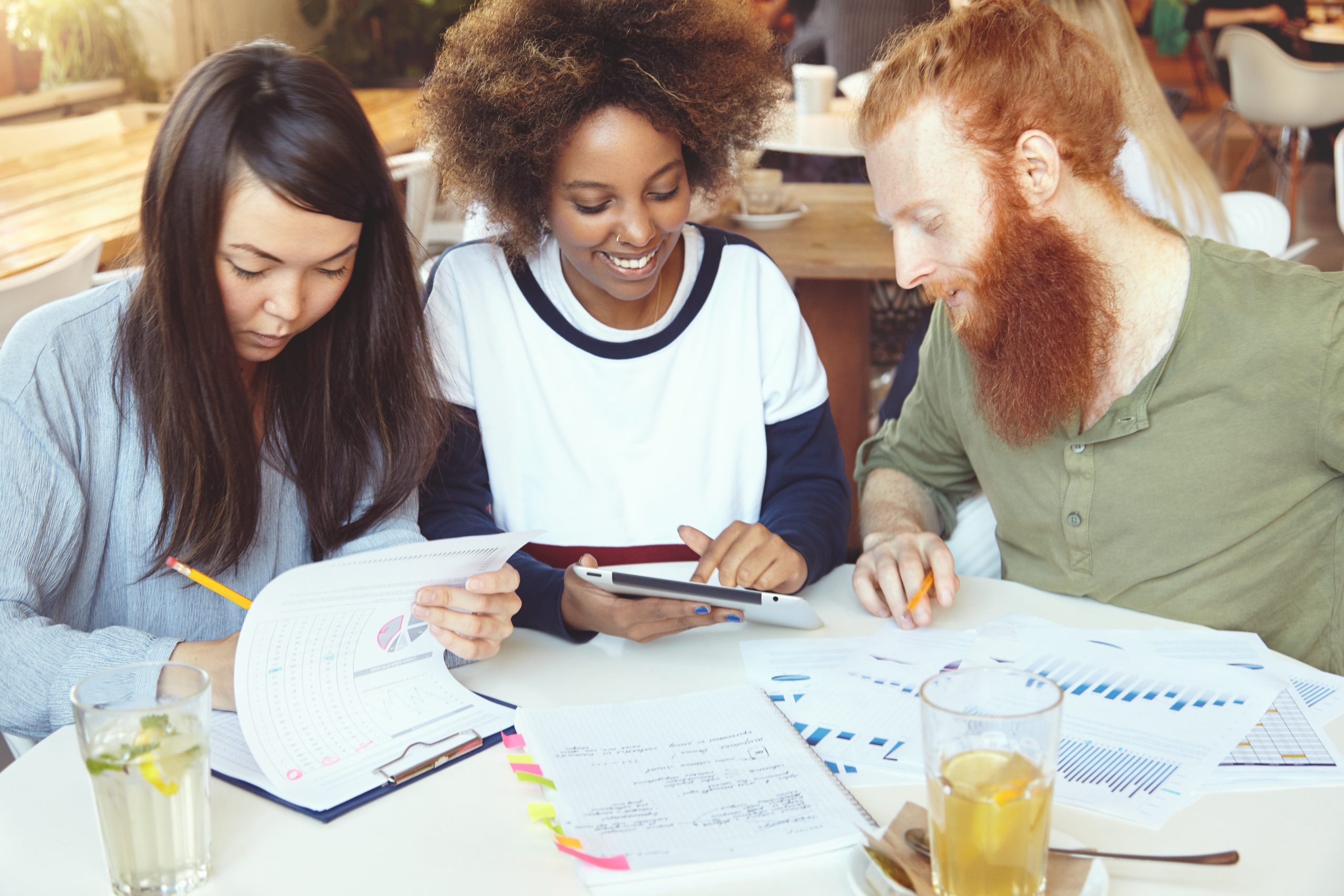Tres personas jóvenes trabajan juntas en un proyecto.