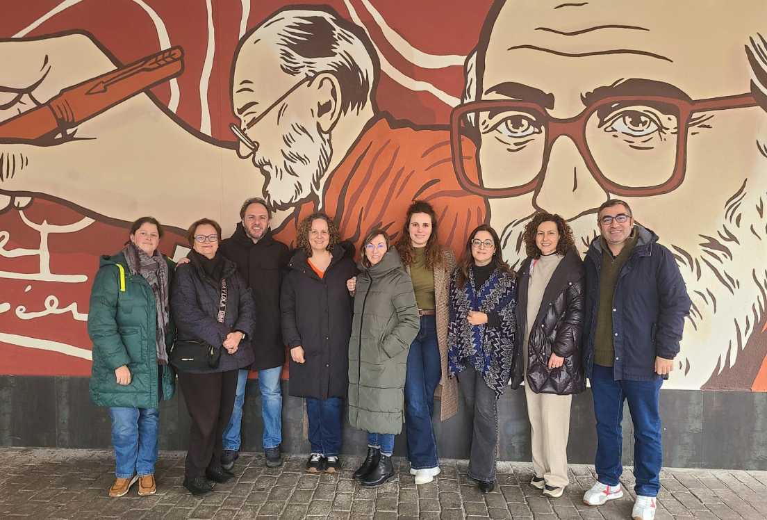 Grupo de personas de pie delante de un mural